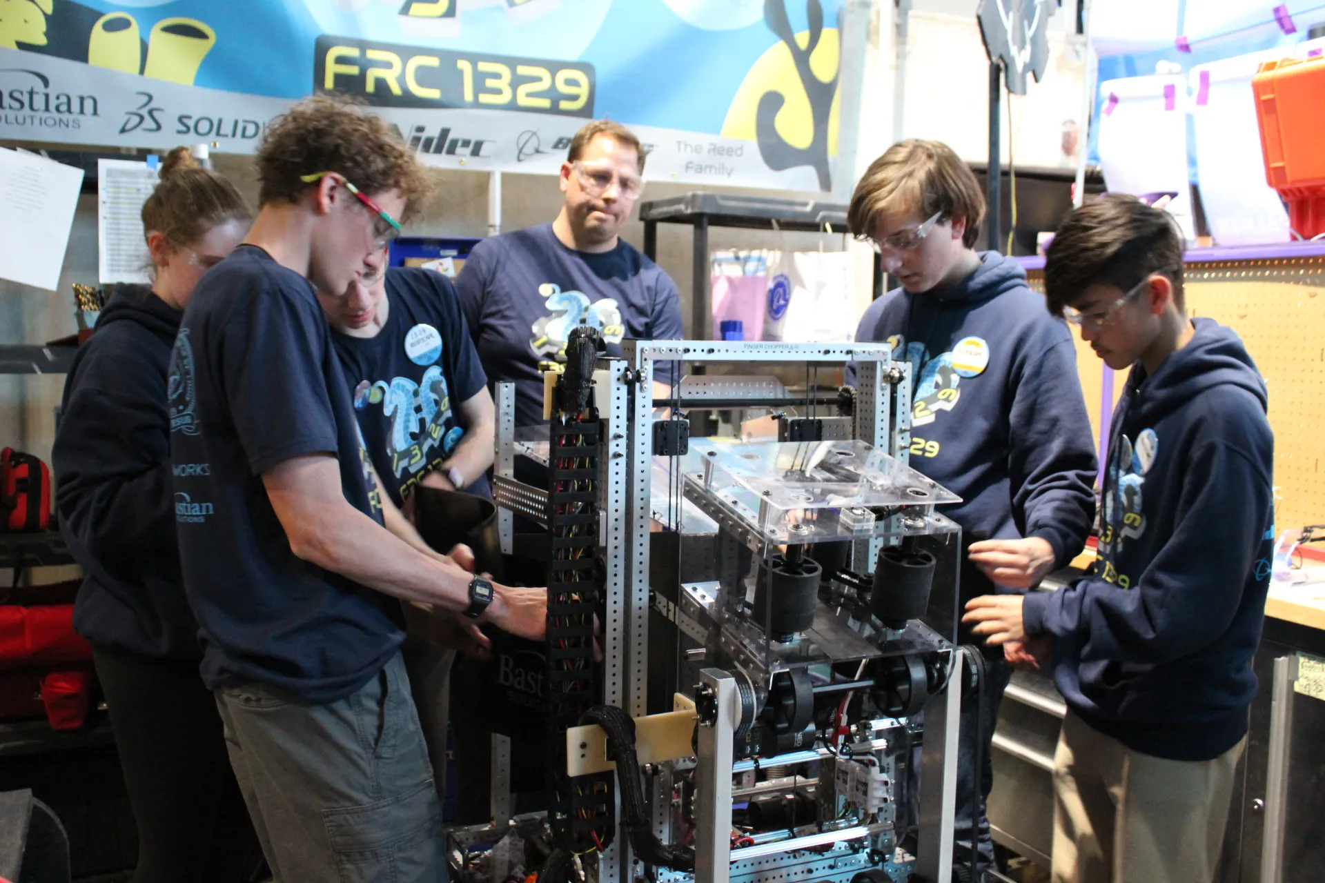 ViPrs students and a mentor working on the robot in the team's competition pit